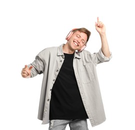 Photo of Happy man listening to music in headphones and dancing on white background