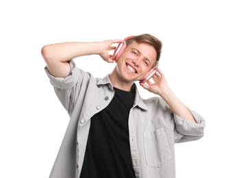 Photo of Happy man listening to music in headphones and dancing on white background