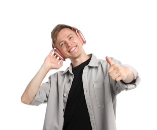 Photo of Happy man listening to music in headphones and dancing on white background