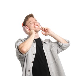 Photo of Happy man listening to music in headphones and dancing on white background
