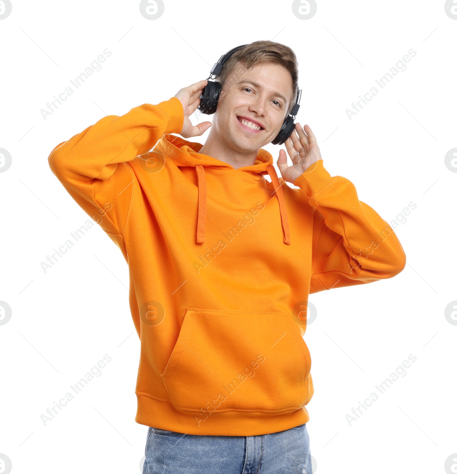 Happy man listening to music in headphones and dancing on white background Photo of Happy man listening to music in headphones and dancing on white background