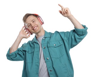 Photo of Happy man listening to music in headphones and dancing on white background