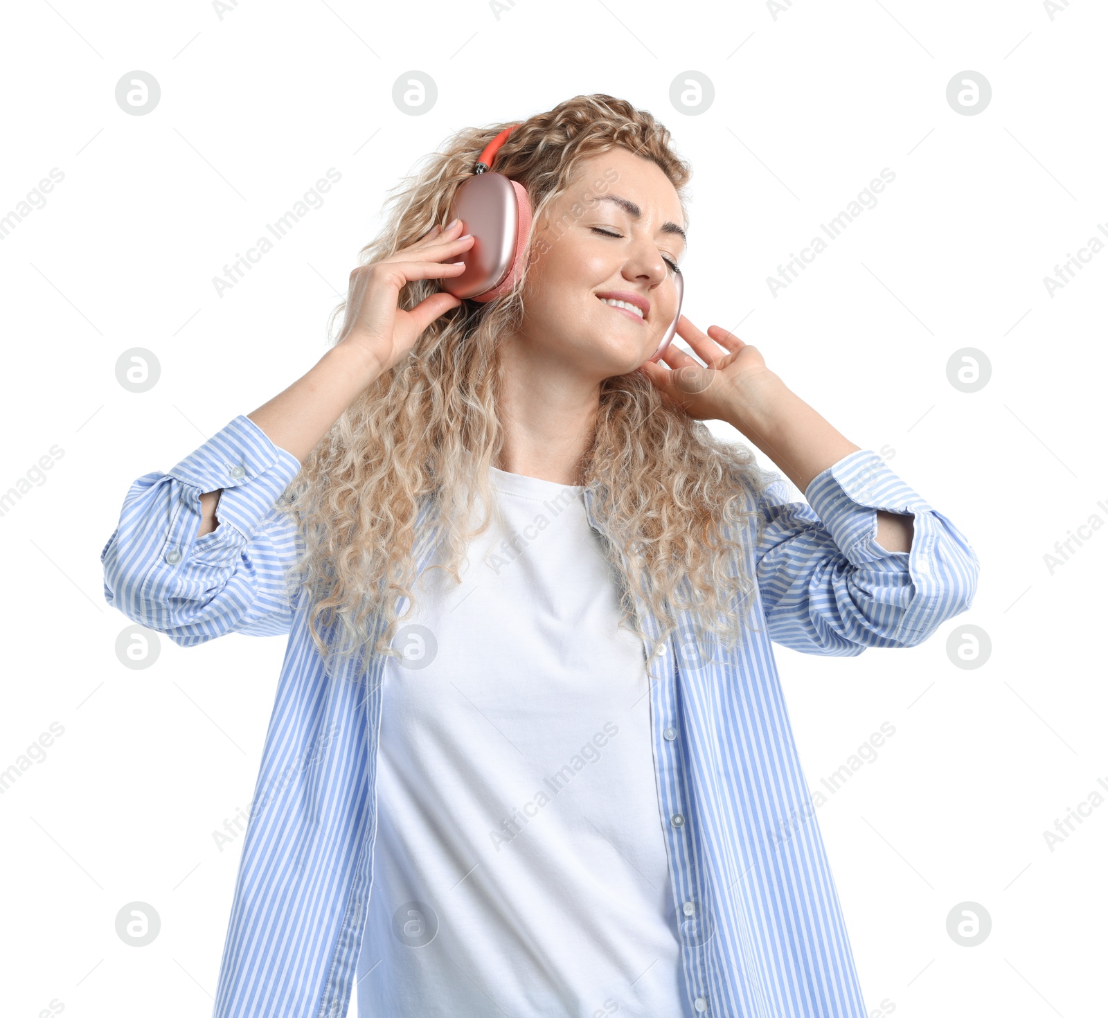 Photo of Happy woman listening to music in headphones and dancing on white background