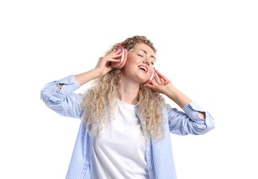Photo of Happy woman listening to music in headphones and dancing on white background
