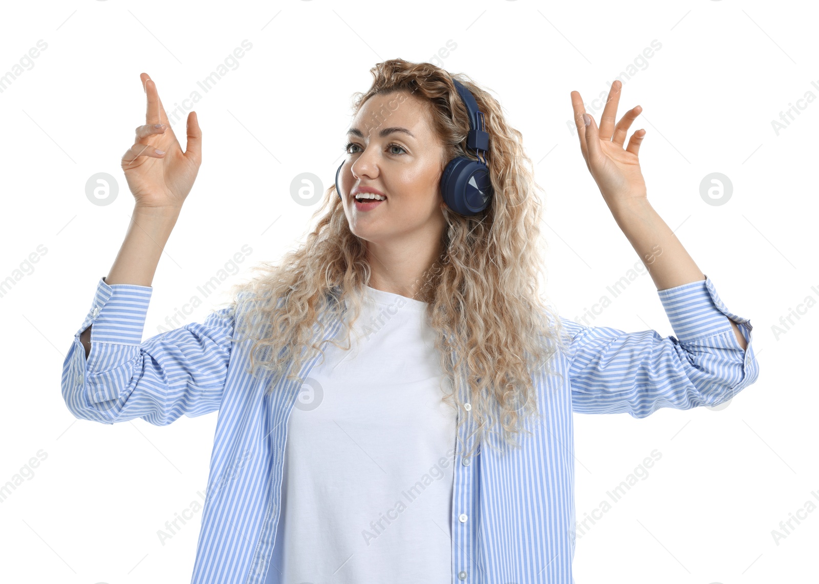 Happy woman listening to music in headphones and dancing on white background Photo of Happy woman listening to music in headphones and dancing on white background