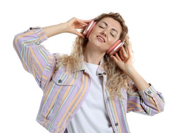 Photo of Happy woman listening to music in headphones and dancing on white background