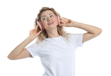 Photo of Happy woman listening to music in headphones and dancing on white background