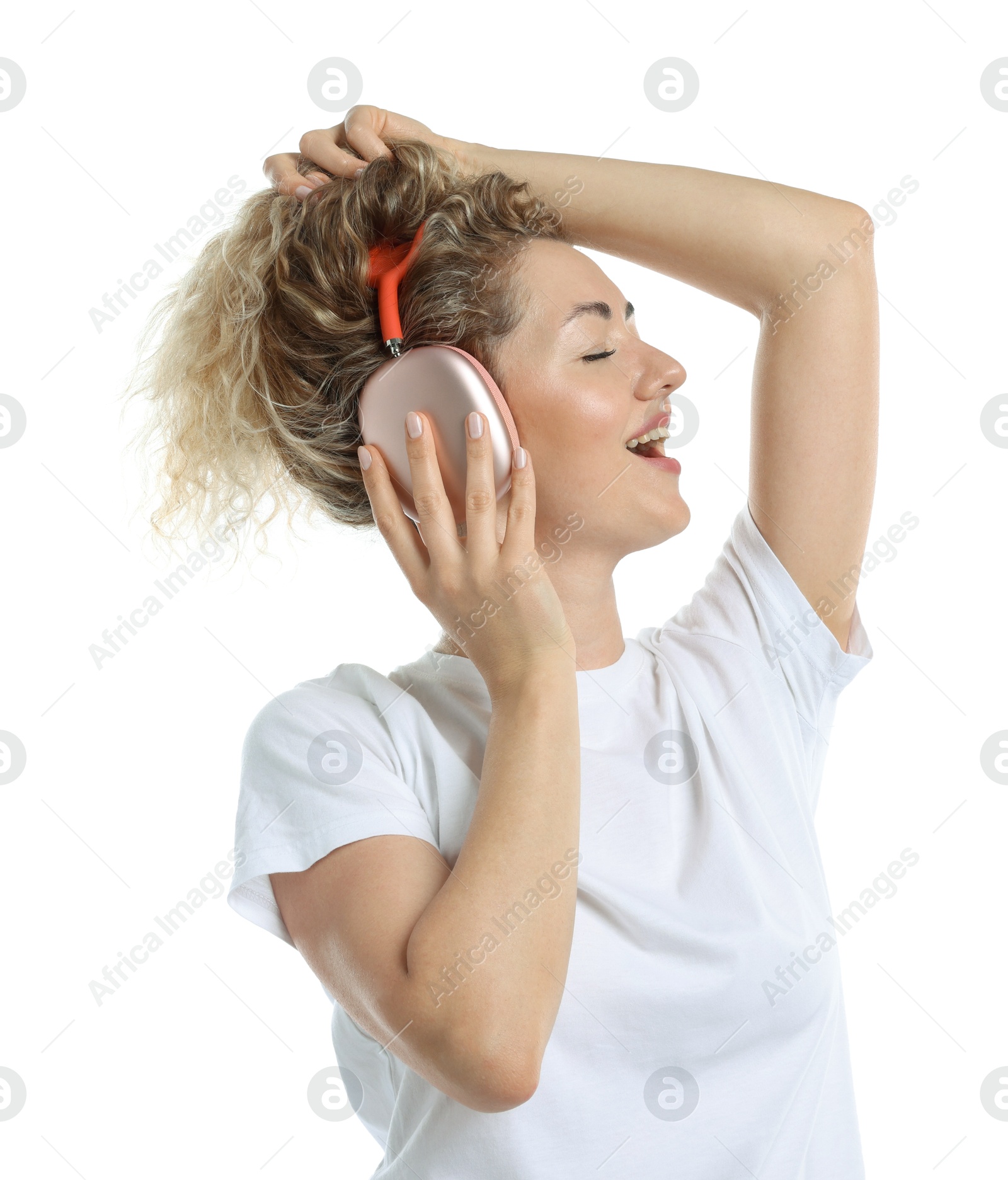 Happy woman listening to music in headphones and dancing on white background Photo of Happy woman listening to music in headphones and dancing on white background