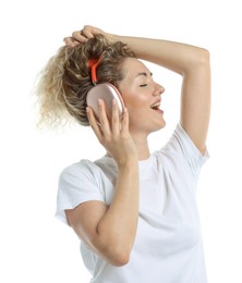 Photo of Happy woman listening to music in headphones and dancing on white background