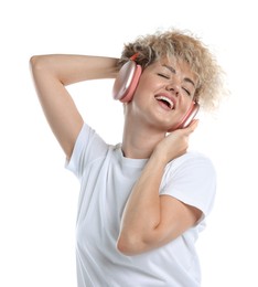 Photo of Happy woman listening to music in headphones and dancing on white background