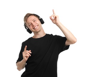Photo of Happy man listening to music in headphones and dancing on white background