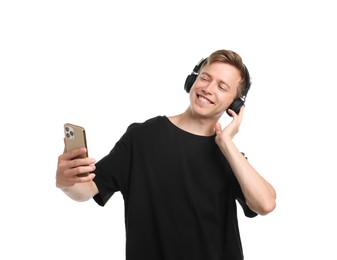 Photo of Happy man with smartphone listening to music in headphones on white background