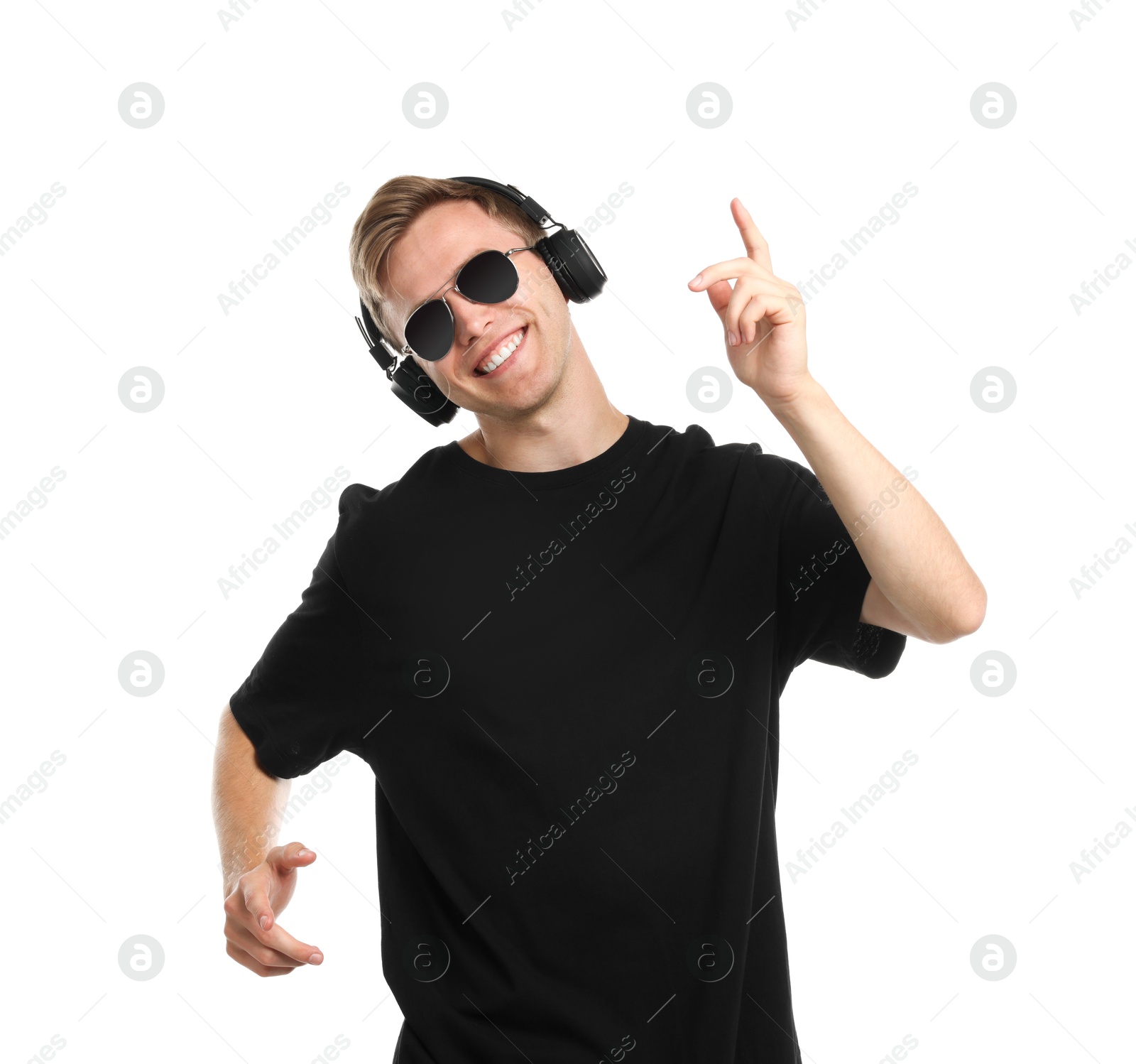 Happy man listening to music in headphones and dancing on white background Photo of Happy man listening to music in headphones and dancing on white background