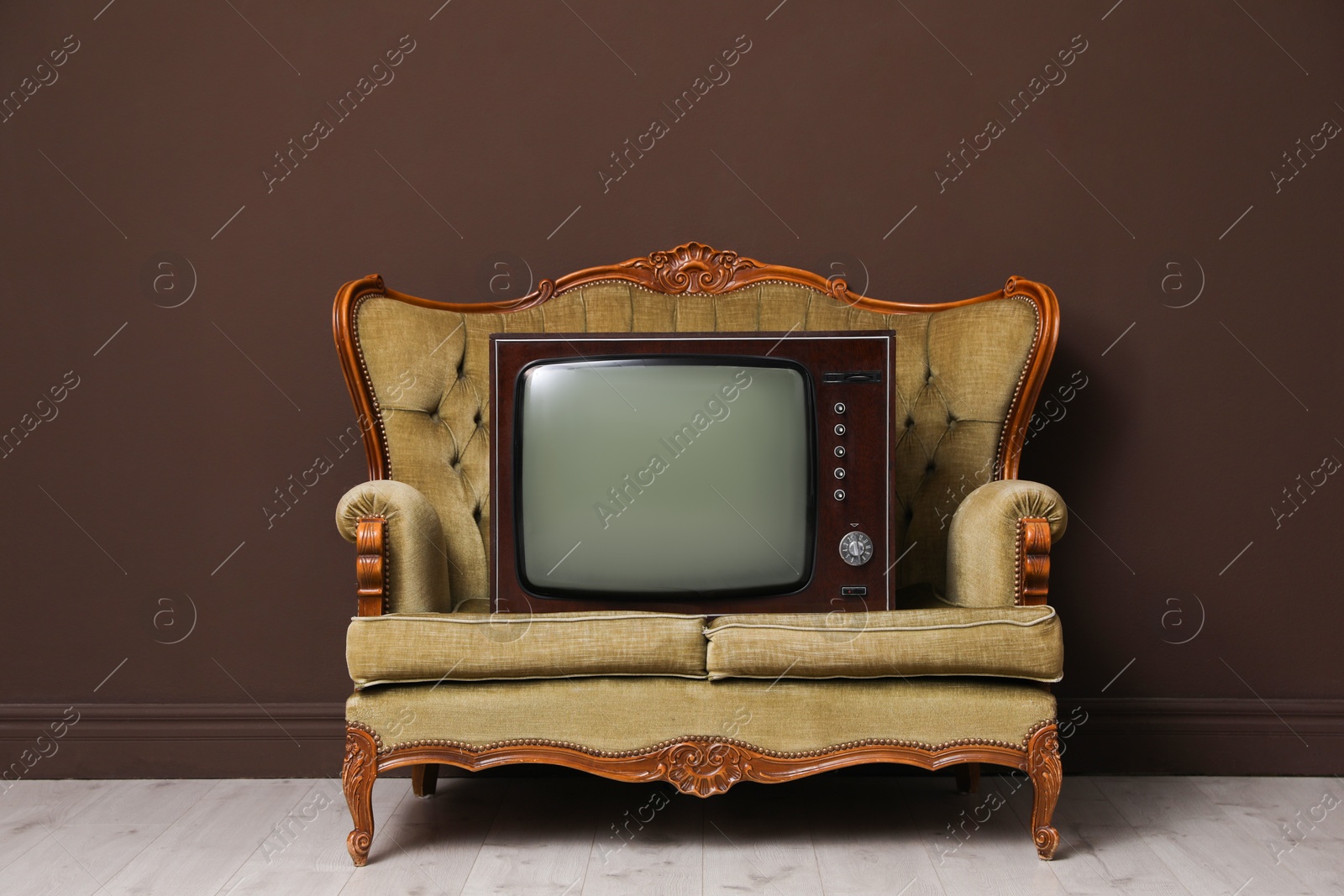 Retro TV on sofa near brown wall. Used stuff Photo of Retro TV on sofa near brown wall. Used stuff