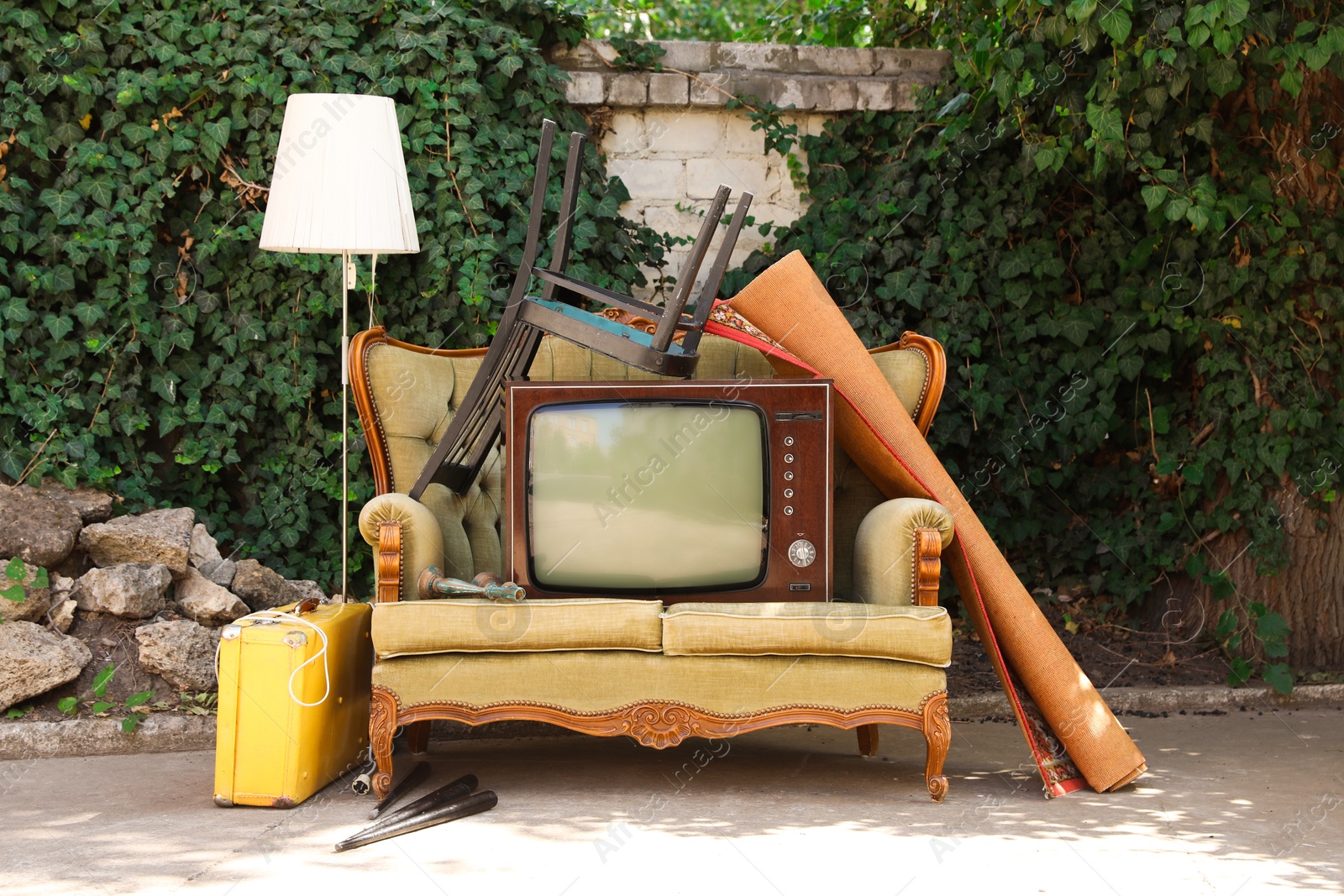 Retro TV on sofa and other used stuff outdoors Photo of Retro TV on sofa and other used stuff outdoors