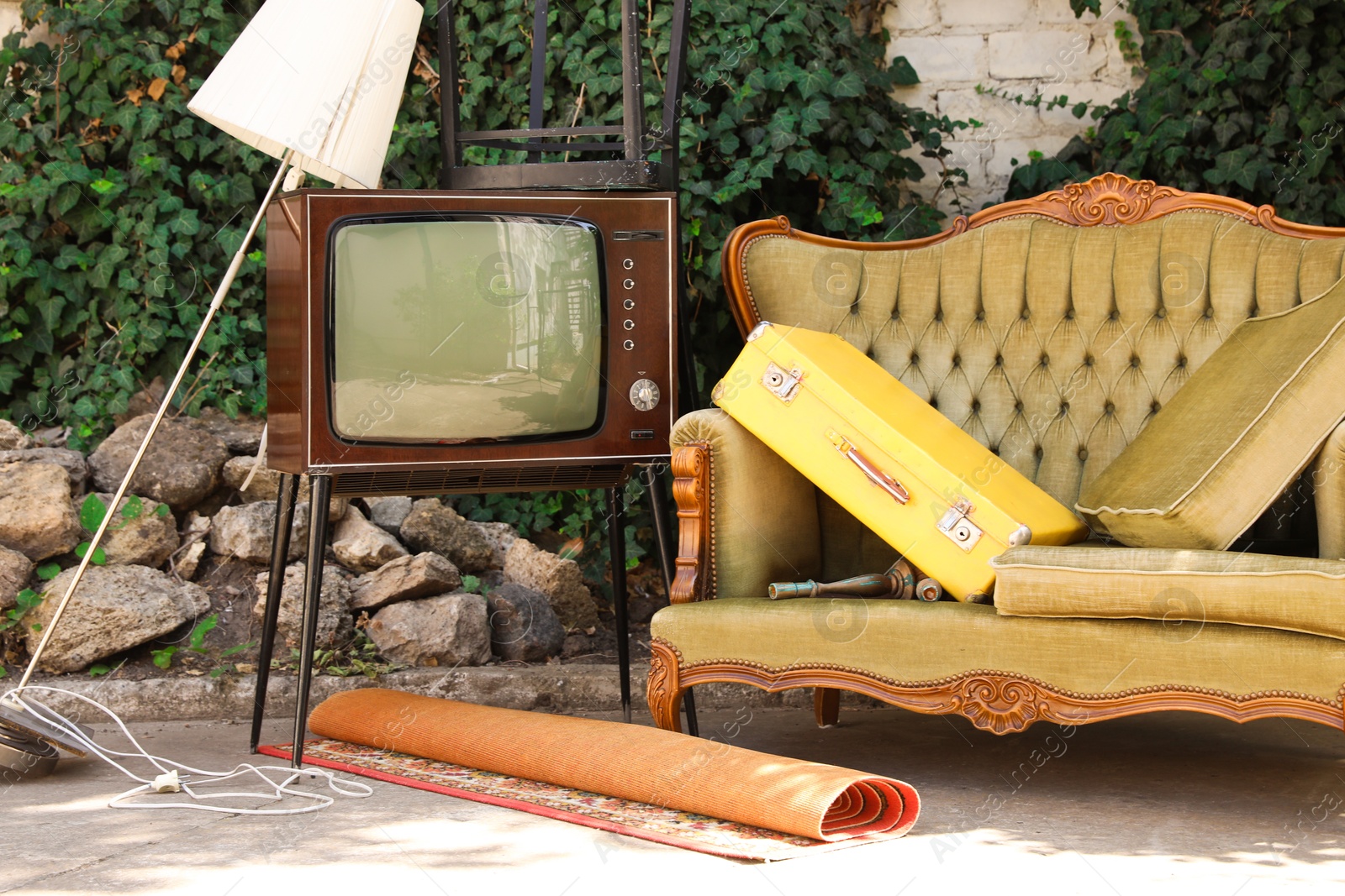 Retro TV on stand, sofa and other used stuff outdoors Photo of Retro TV on stand, sofa and other used stuff outdoors