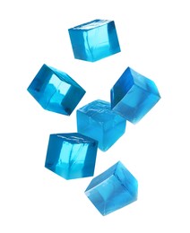 Image of Yummy blue jelly cubes falling on white background