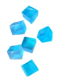 Image of Yummy blue jelly cubes falling on white background