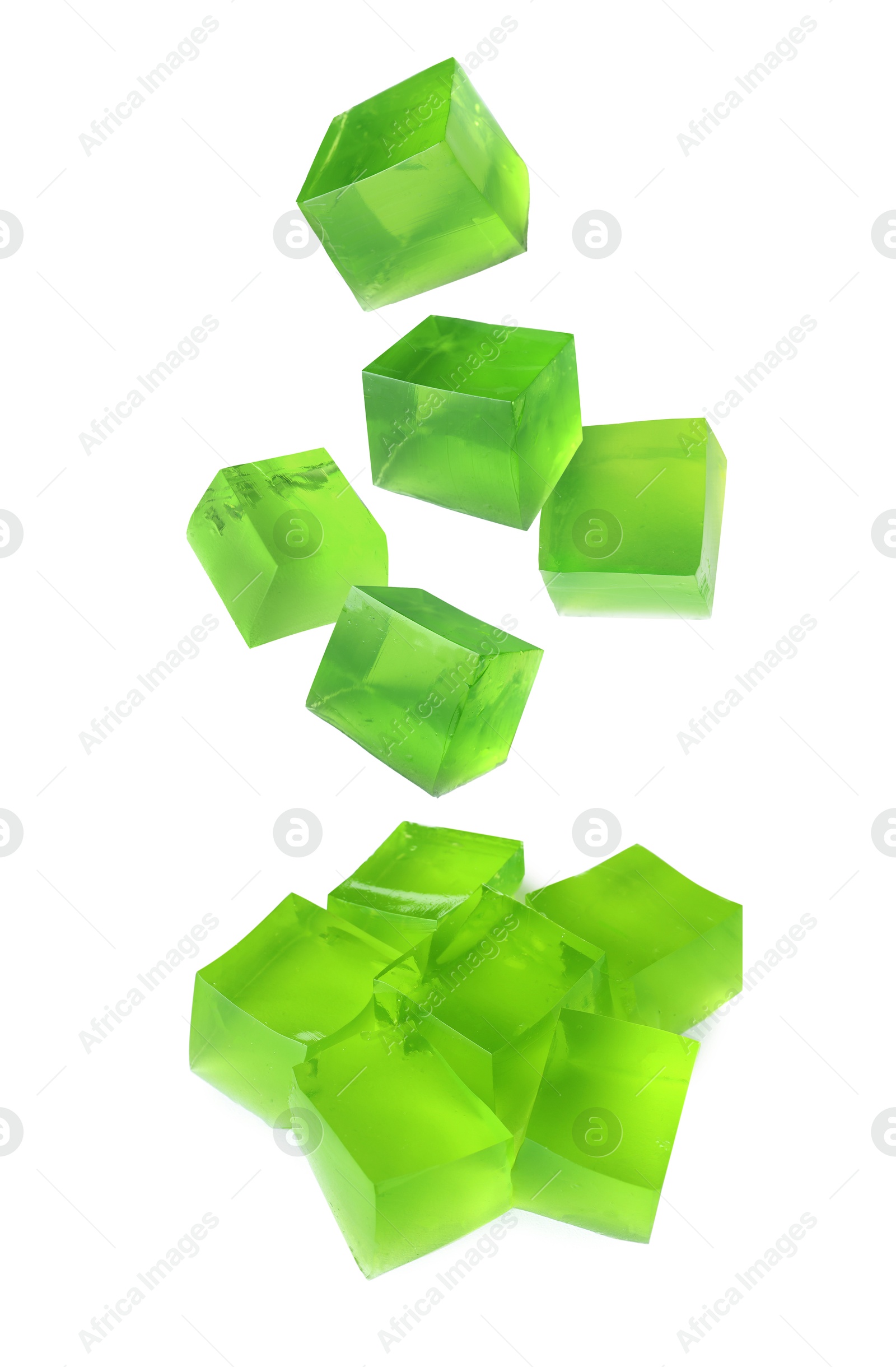 Image of Yummy green jelly cubes falling on white background