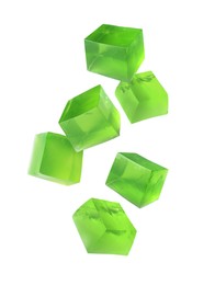 Image of Yummy green jelly cubes falling on white background