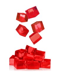 Image of Yummy red jelly cubes falling on white background
