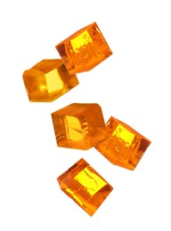 Image of Yummy orange jelly cubes falling on white background
