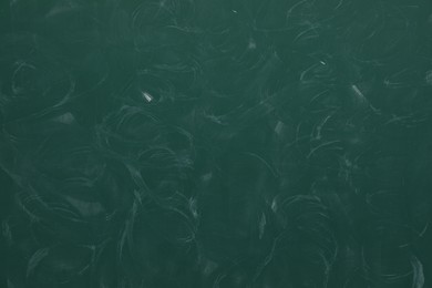Photo of Dirty green chalkboard as background. School equipment