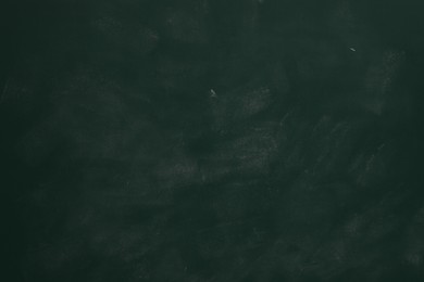Photo of Chalk rubbed out on green chalkboard as background, closeup. Space for text