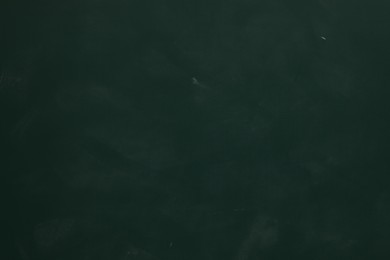 Photo of Chalk rubbed out on green chalkboard as background, closeup. Space for text