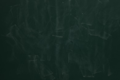 Photo of Chalk rubbed out on green chalkboard as background, closeup. Space for text