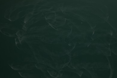 Photo of Chalk rubbed out on green chalkboard as background, closeup. Space for text