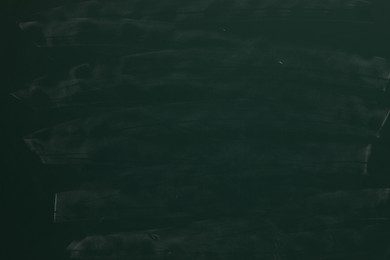 Photo of Chalk rubbed out on green chalkboard as background, closeup. Space for text