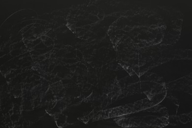 Photo of Chalk rubbed out on black chalkboard as background, closeup. Space for text
