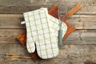Photo of Oven glove and other kitchen utensils on wooden table, top view