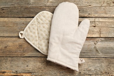 Photo of Oven glove and potholder on wooden table, top view