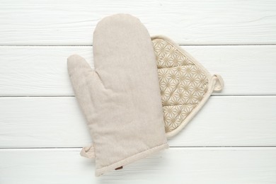Photo of Oven glove and potholder on white wooden table, top view