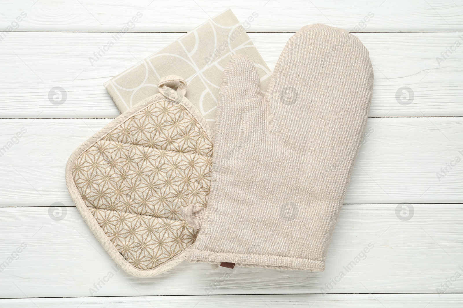 Oven glove, potholder and towel on white wooden table, top view Photo of Oven glove, potholder and towel on white wooden table, top view