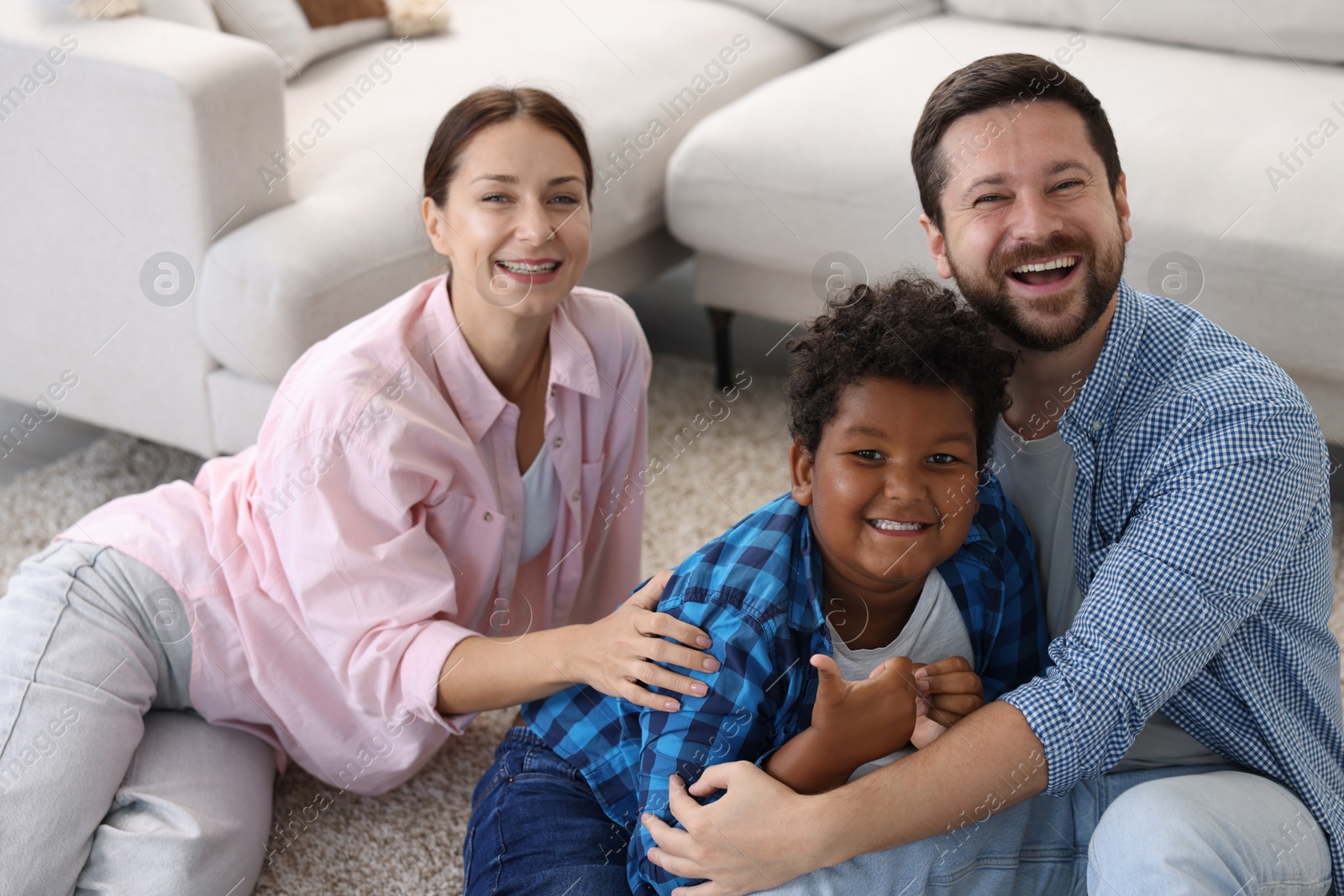Adoption. Happy parents with their son on floor at home Photo of Adoption. Happy parents with their son on floor at home