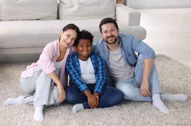 Photo of Adoption. Happy parents with their son on floor at home