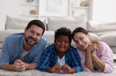 Photo of Adoption. Happy parents with their son on floor at home