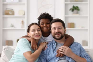 Photo of Adoption. Happy parents and their son at home