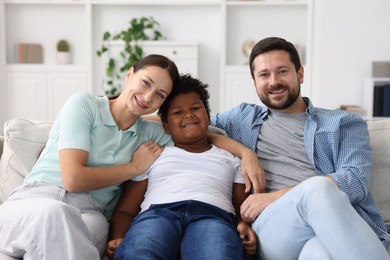 Photo of Adoption. Happy parents and their son at home
