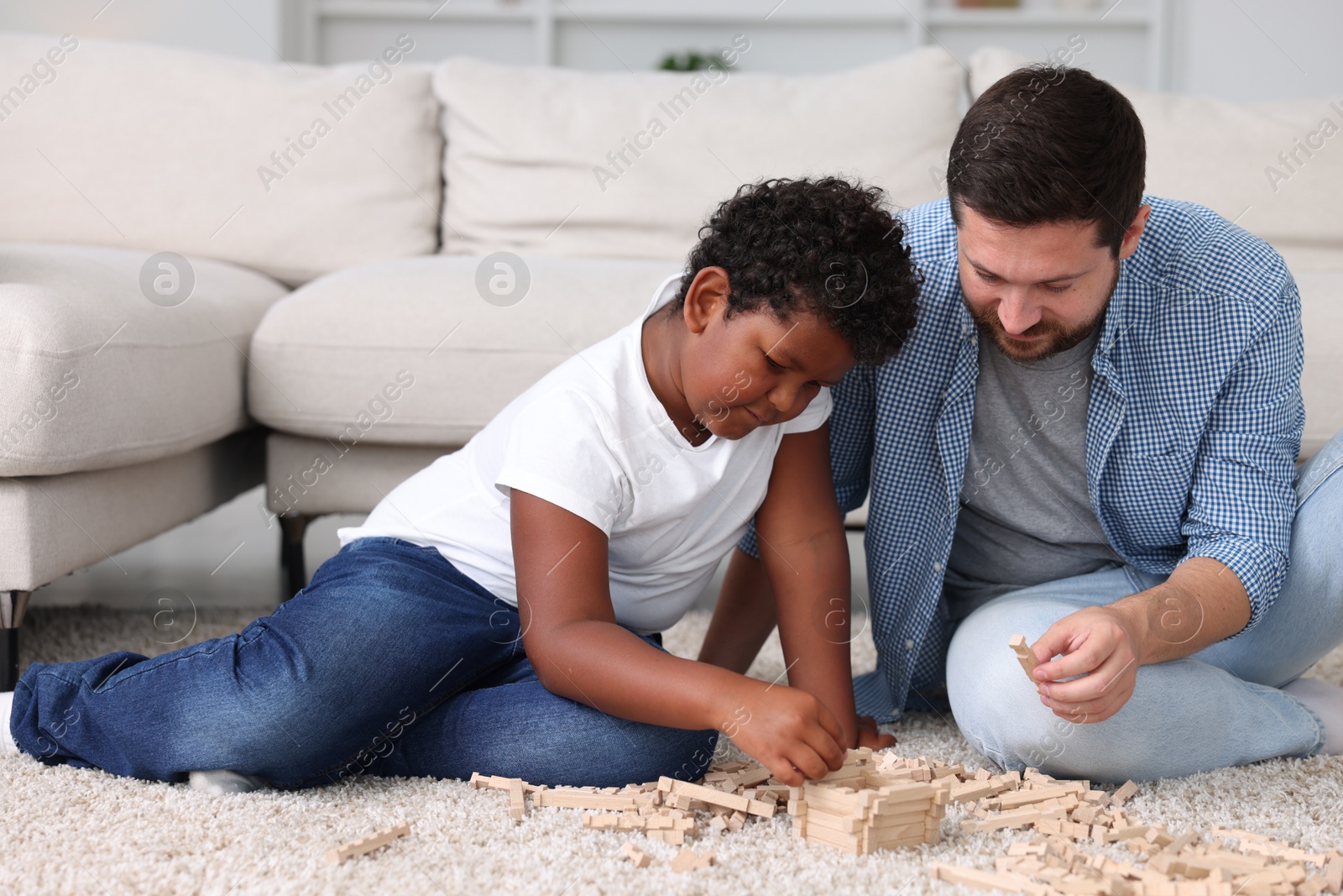 Adoption. Father and his son playing with wooden blocks on floor at home Photo of Adoption. Father and his son playing with wooden blocks on floor at home