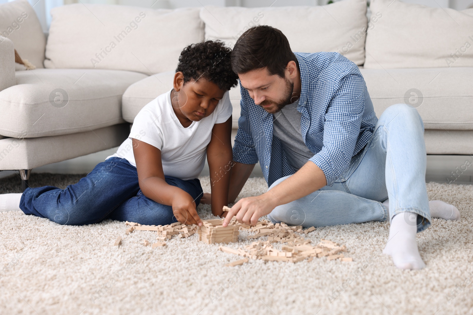 Adoption. Father and his son playing with wooden blocks on floor at home Photo of Adoption. Father and his son playing with wooden blocks on floor at home