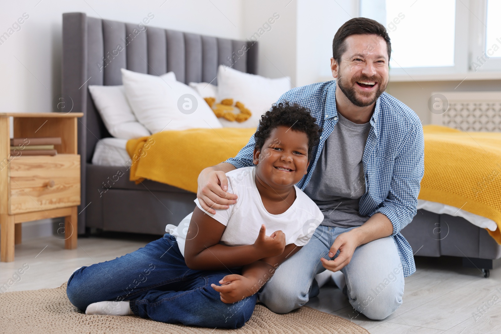 Photo of Adoption. Father and his son on floor at home