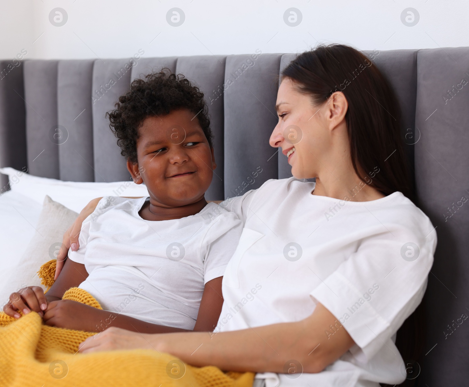 Photo of Adoption. Mother and her son on bed at home