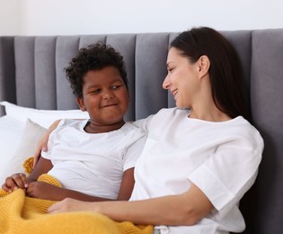 Photo of Adoption. Mother and her son on bed at home