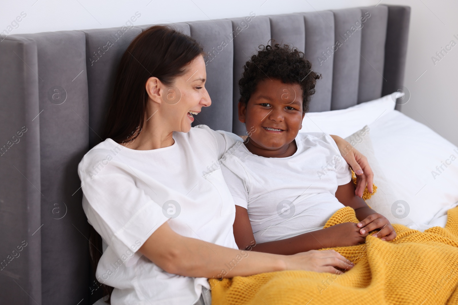 Photo of Adoption. Mother and her son on bed at home