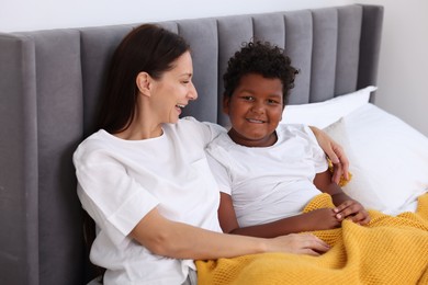 Photo of Adoption. Mother and her son on bed at home