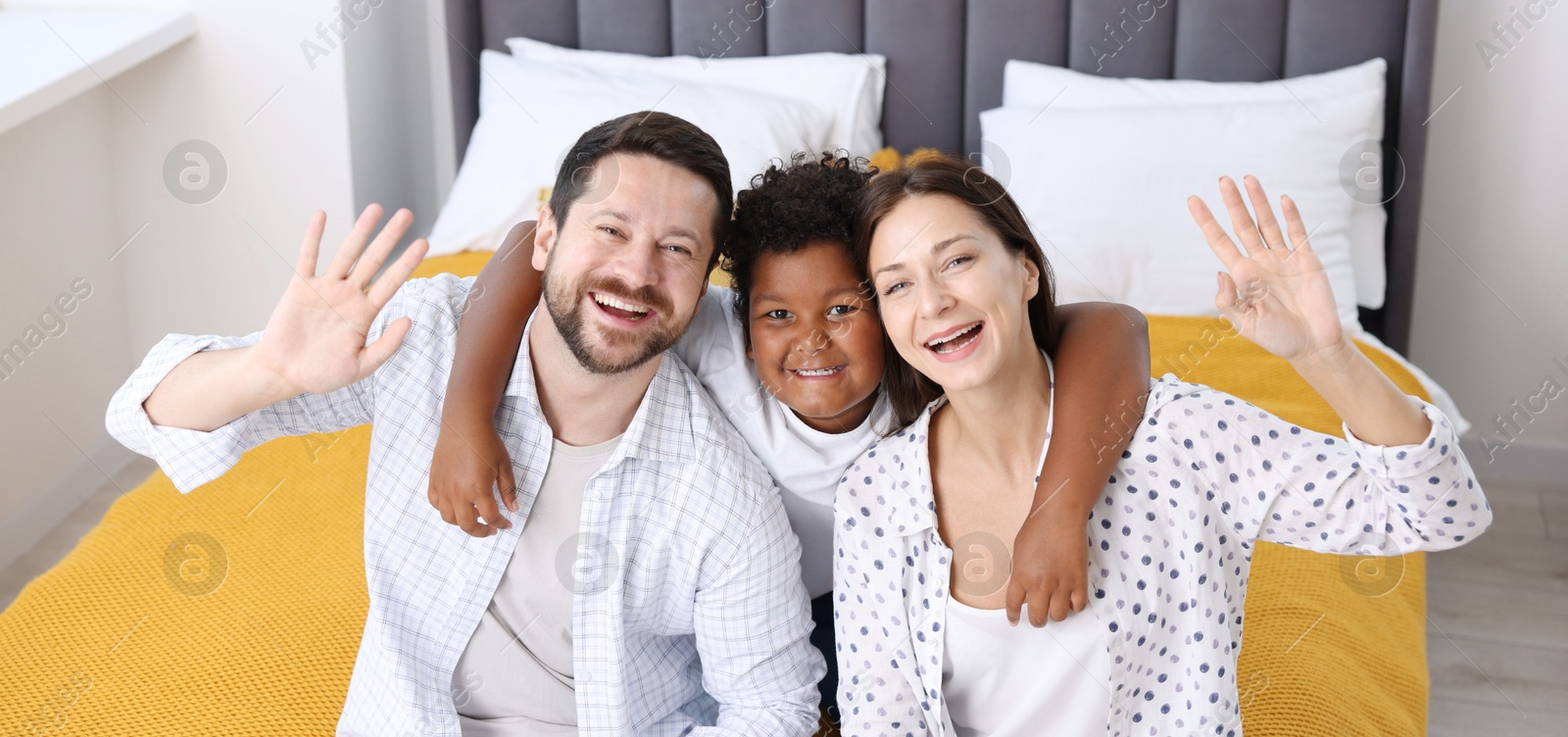 Adoption. Happy parents and their son on bed at home Photo of Adoption. Happy parents and their son on bed at home